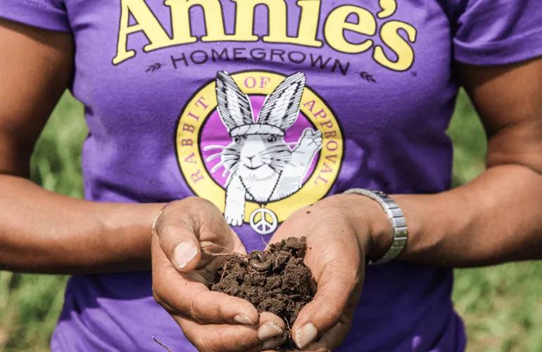 Women holding organic soil with earthworm in it